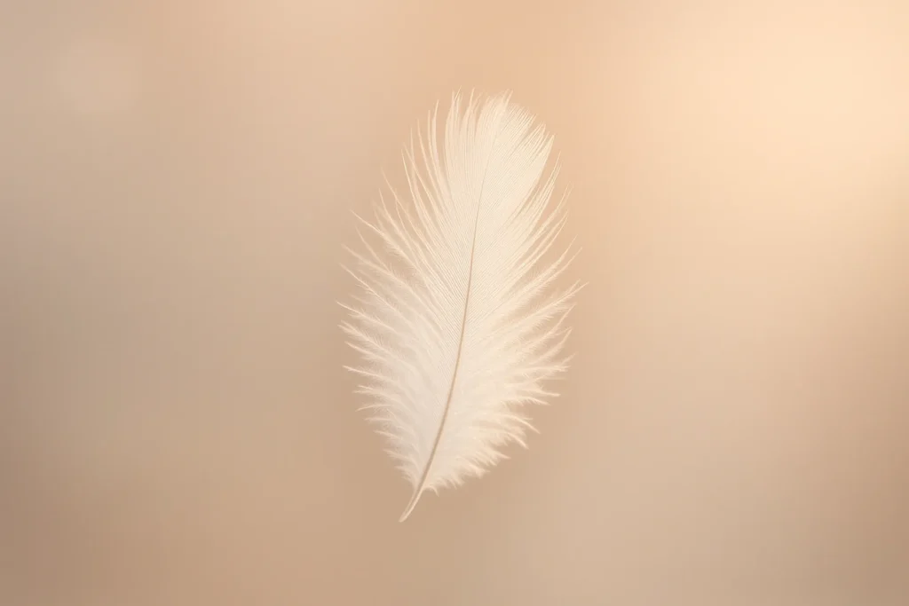 A single delicate white feather suspended in midair, captured close-up against a soft, blurred neutral background in warm pastel tones. Gentle rim lig...